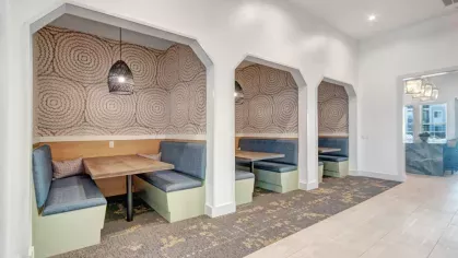 Modern co-working and relaxation space with stylish purple seating, unique lighting fixtures, and a refined interior design.