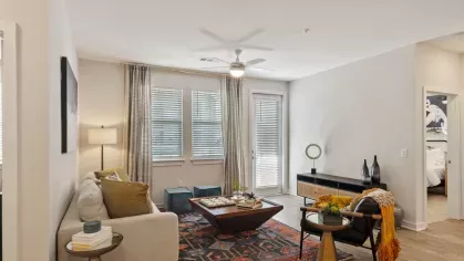 A beautifully decorated living room with a neutral sofa, patterned throw pillows, and a statement coffee table, complemented by a textured area rug.
