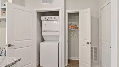 Walk-in closet with white shelving, neatly folded towels, and ample space for hanging clothes and storage.