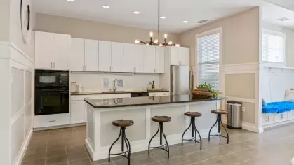 A spacious kitchen and dining area featuring a farmhouse-style wooden table and a large island.