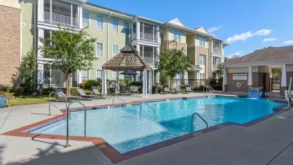 A contemporary outdoor fireplace with brick detailing and comfortable seating in a covered patio area.