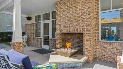 A large communal space with tiled flooring, a long dining table, and a lounge area with a fireplace.