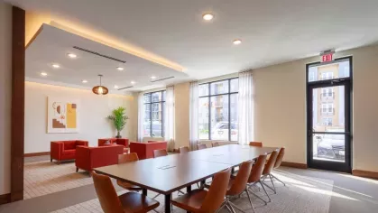 A private dining and meeting area with a long table, leather chairs, and contemporary décor, offering a sophisticated space for gatherings.