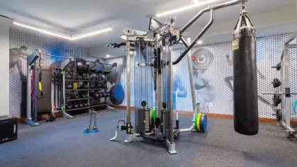 Functional training area equipped with a multi-station weight machine, punching bag, resistance bands, and medicine balls, designed for high-intensity workouts at The Everly Luxury Apartments.