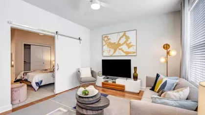 A contemporary living room featuring a stylish TV console, plush seating, and a decorative gold-accented artwork for an elegant touch.