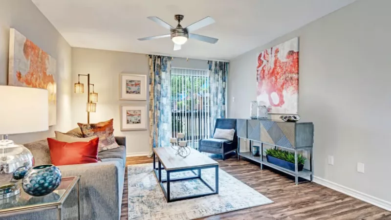 Another angle of the living room highlighting modern furnishings, artwork, and natural light.