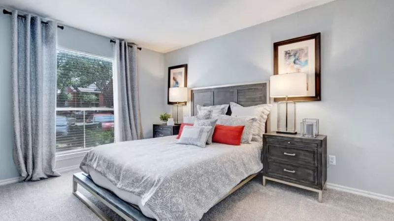 Tranquil bedroom with a wooden bed frame, plush bedding, and soft natural light filtering through the window.