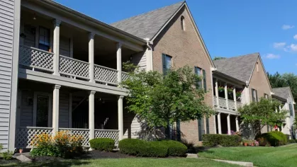 Well-maintained apartment buildings with brick and siding exteriors, featuring upper-level balconies and neatly landscaped grounds.