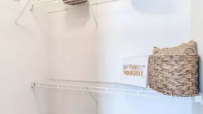 Walk-in closet with wire shelving and decorative storage baskets at The Landings of Conroe Luxury Apartments.