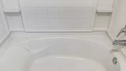 Spacious white bathtub with elegant tile surround at The Landings of Conroe Luxury Apartments.