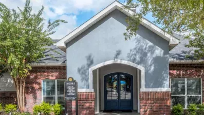 Inviting leasing office entrance with modern architecture and charming brick accents at The Landings of Conroe Luxury Apartments.
