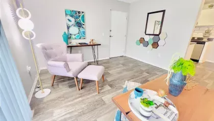 Stylish home office with a pastel armchair, decorative wall art, and a light wood desk.