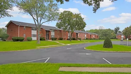 A wide view of the Laurel Run Village apartment complex with winding roads, green lawns, and mature trees.