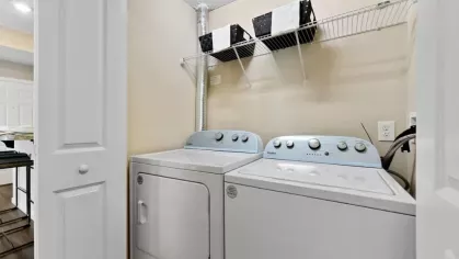 Convenient in-unit laundry area featuring a washer and dryer, neatly tucked behind folding doors for easy access.