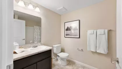 Stylish bathroom with a large vanity, spacious mirror, and contemporary decor, offering a relaxing retreat.