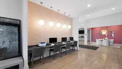 A dedicated workspace with multiple computer stations, contemporary chairs, and pendant lighting, designed for residents at Lawndale Commons.