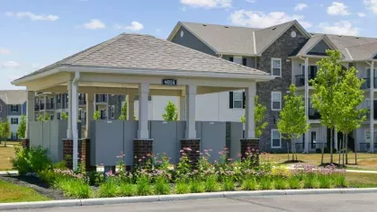 A covered mail center with a landscaped garden at Lawndale Commons Palm Luxury Apartments, featuring a well-maintained design for resident convenience.