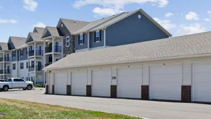 A row of private garages at Lawndale Commons, offering secure storage and parking options for residents, with modern apartment buildings in the background