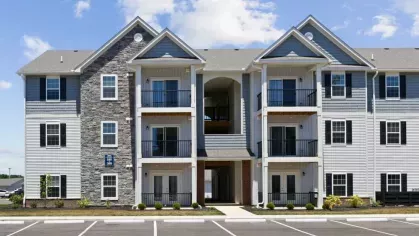 A direct front view of a Lawndale Commons apartment building, showcasing its contemporary design, spacious balconies, and welcoming entrance.