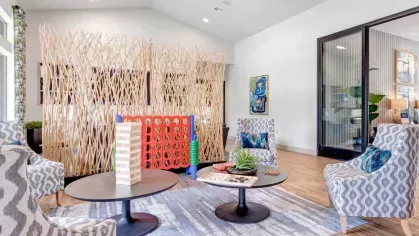 Vibrant game and lounge area with cozy seating, a large Connect Four game, and modern décor, perfect for relaxation and entertainment.