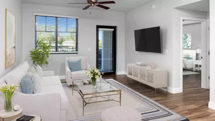 A well-lit, modern living room with a wall-mounted TV, elegant décor, and direct access to a private balcony at Locklyn West Palm.