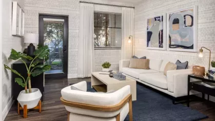 A spacious layout with a cozy seating area, sleek shelving, and a gourmet kitchen with stainless steel appliances and an island for casual dining.