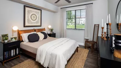 A serene bedroom with a leather-upholstered headboard, plush bedding, and decorative accents that create a warm, inviting atmosphere.