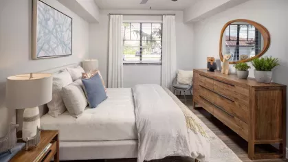 A beautifully designed bedroom with a neutral color scheme, a statement dresser, and elegant decor that creates a tranquil retreat.