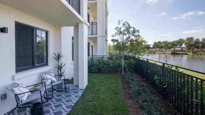 Lush private patio overlooking a scenic lake, complete with comfortable outdoor seating and greenery. A peaceful setting to relax and enjoy nature at Locklyn West Palm.