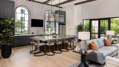 A sophisticated co-working space with arched doorways, modern artwork, a built-in desk, and cozy seating for a productive environment.