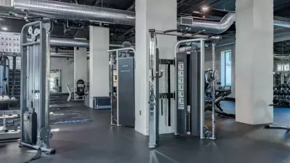 Well-equipped fitness center featuring strength training machines and industrial design elements.