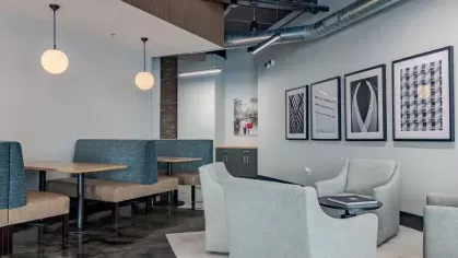 Contemporary seating area with booth-style dining and soft blue armchairs under modern lighting.