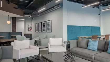 Modern lounge area with comfortable seating, sleek decor, and a polished concrete floor.