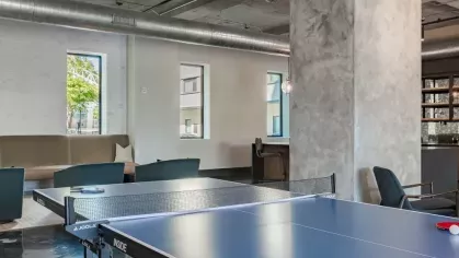 Recreation area with ping pong tables, industrial design, and relaxed seating.