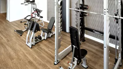 A strength training area with a power rack, free weights, and modern fitness equipment in The Mark at Mamaroneck’s upscale gym.