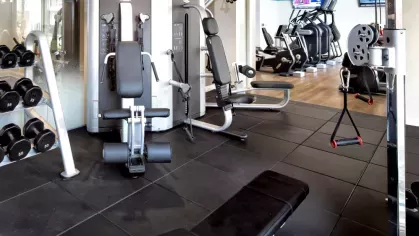 A fully equipped gym featuring weight machines, free weights, and cardio equipment, offering residents a high-end workout experience.