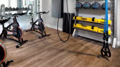 A boutique-style fitness studio with spin bikes, TRX suspension training, and a Wellbeats virtual fitness screen for on-demand workouts.