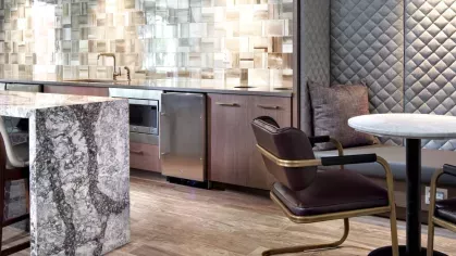 A modern kitchen area with a marble island, stylish tile backsplash, and built-in seating, seamlessly blending functionality with upscale aesthetics.