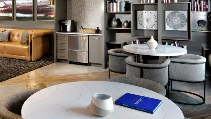 Chic resident lounge with plush seating, built-in bookshelves, and a stylish kitchenette, perfect for relaxation and socializing.