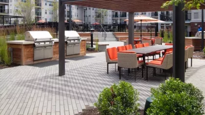 A well-maintained outdoor space with lush plants, paved walkways, and communal seating areas for residents.