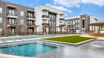 A luxury apartment community pool with a built-in spa, sleek sundeck, and contemporary architecture.