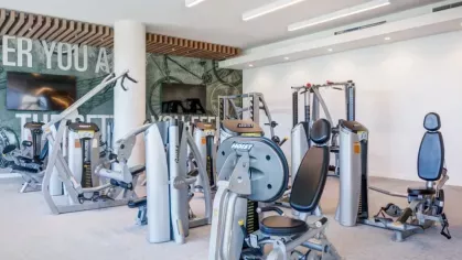 A fitness center with advanced strength training machines and motivational wall art.