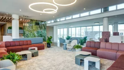 Modern lounge area with circular ceiling lights and floor-to-ceiling windows.