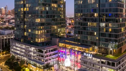 Evening view of the Nari towers with vibrant lighting, showcasing the bustling streets of Koreatown in Los Angeles.