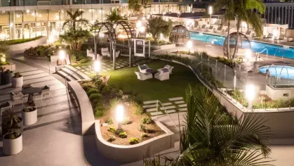 Night view of the rooftop pool area at Nari, featuring modern landscaping, cozy seating, and a tranquil ambiance.