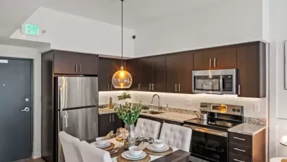 A stylish kitchen with a built-in dining space, plush seating, and a contemporary design complemented by warm lighting and modern finishes.