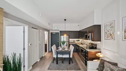 A cozy dining area adjacent to a fully equipped kitchen with sleek stainless steel appliances, elegant finishes, and ample storage space.