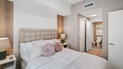  The Oak Enclave bedroom offers a cozy retreat with a neutral color scheme, soft lighting, and direct access to a modern bathroom.