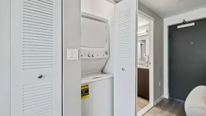 Convenience meets luxury with a stackable washer and dryer tucked into a dedicated laundry space at Oak Enclave Apartments.