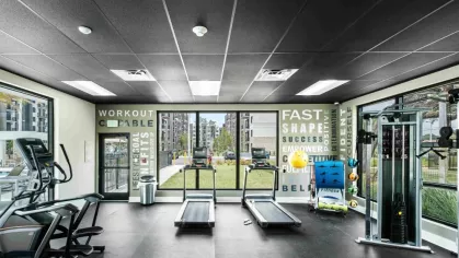 A stylish fitness center at Oak Enclave featuring top-tier machines, resistance training equipment, and motivational wall decor.